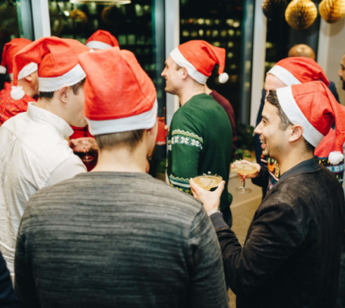 A group of colleagues wearing santa hats and drinking cocktails in one of Uncommon's London event spaces