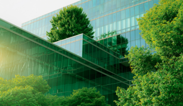 Glass-fronted office building surrounded by trees